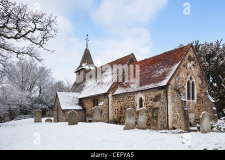 San Nicola, Chiesa Hill, Pyrford, Surrey in Inghilterra con lapidi tomba nel cimitero, nella neve Foto Stock