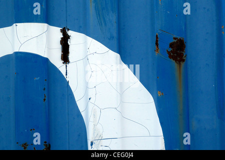 Ondulato della superficie metallica di un container di spedizione con dipinto di bianco di un grafico Foto Stock