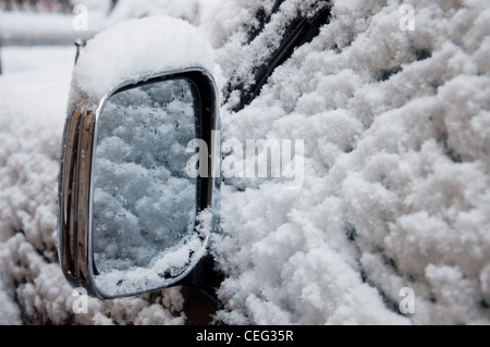 Ala auto mirror di tutto coperto di neve, chiudi immagine in alto Foto Stock