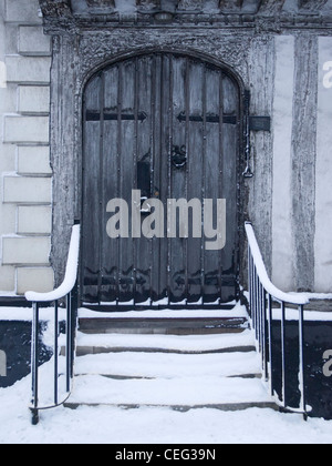 Coperte di neve passi fino ad una chiusa di legno vecchio porta ad arco Foto Stock