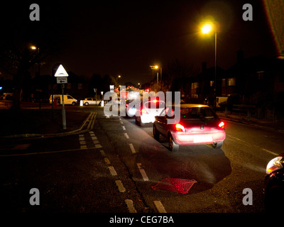 Automobili in attesa presso un passaggio a livello di notte a Motspur Park Station in SW London Inghilterra England Foto Stock