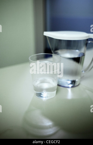 Bere acqua di rubinetto da una brocca e bicchiere in ospedale Foto Stock