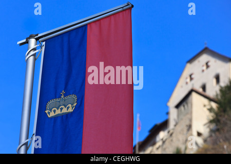 La bandiera ufficiale del Liechtenstein in primo piano e il castello di Vaduz in background, Liechtenstein Foto Stock