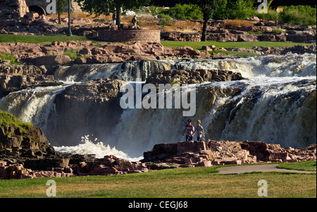 Una coppia in piedi davanti a una cascata vista frontale American Sioux Falls Big Sioux River City Park Queen Bee Mill Ruins South Dakota negli Stati Uniti ad alta risoluzione orizzontale Foto Stock