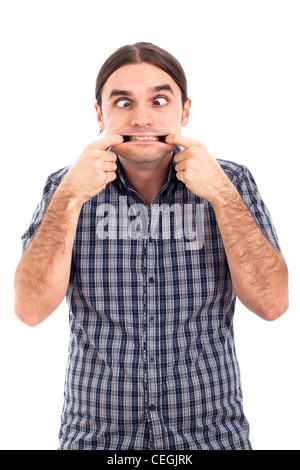 Giovane uomo facendo facce buffe, isolato su sfondo bianco. Foto Stock