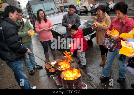 Chinese-Americans bruciando denaro simbolico per fortuna per le strade della città di New York Chinatown durante 2012 capodanno nuovo anno lunare Foto Stock