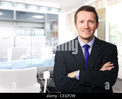 Sorridente giovane lavoratore in un ufficio moderno Foto Stock