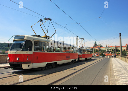 Tram rosso passando sul Ponte Manes (Manesuv Most) e il famoso Castello di Praga sullo sfondo a Praga, Repubblica Ceca. Foto Stock