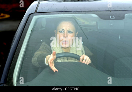 Femmina in lei 20 s arrabbiato guidando una macchina con la strada Rabbia gridando ad altri automobilisti UK (posato per modello) Foto Stock