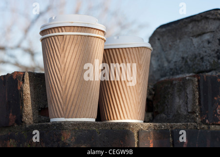 Due caffè usa e getta o tazze tè seduti fianco a fianco su una parete, nessun logo. Foto Stock