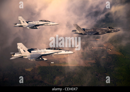 La prima produzione del DoD F-35B Lightning II Joint Strike Fighter vola verso la sua nuova casa alla base dell'aeronautica di Eglin, Fla., scortata dal corpo dei Marine F-18 Hornets. La variante Marina del JSF appartiene allo Squadrone 501 di attacco dei combattente marini. I Marines di VMFAT-501 hanno ricevuto due F-35 Bs dal gennaio 11. Foto Stock