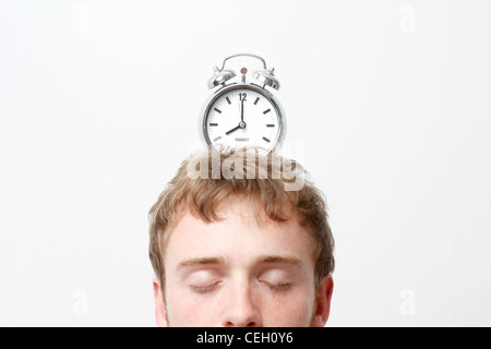 Un uomo con un orologio di allarme sulla cima della sua testa Foto Stock