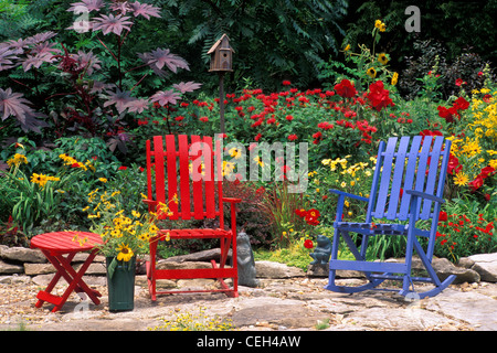 Whimsical giardino estivo in rosso con mobili e fiori che sbocciano, Missouri USA Foto Stock