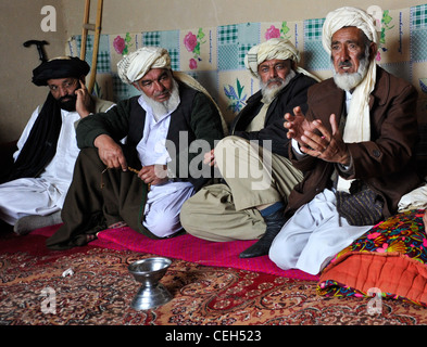 Un anziano del villaggio parla ai membri della polizia locale afghana durante una shura tenuta nel distretto di Shah Joy, provincia di Zabul, Afghanistan, febbraio 11. L'ALP lavora attivamente con gli anziani dei villaggi per promuovere la sicurezza e la stabilità in tutta la regione. Foto Stock