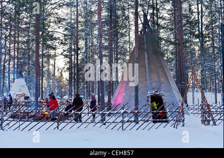 Le persone intorno a un tradizionale tenda in Lapponia Foto Stock