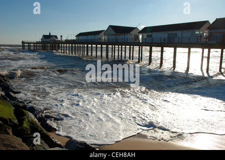 Southwold Pier in una giornata di vento con le onde che si infrangono sulla spiaggia a Southwold Suffolk. Foto Stock