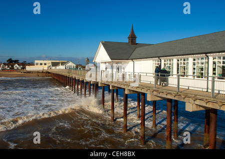 Southwold Pier in una giornata di vento con le onde che si infrangono sulla spiaggia a Southwold Suffolk. Foto Stock