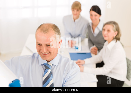 Dando la presentazione imprenditore esecutivo puntando alla lavagna a fogli mobili alla ricerca del team Foto Stock