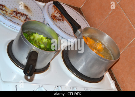 Broccoli e zucca cottura in pentole diverse sulla stufa Foto Stock