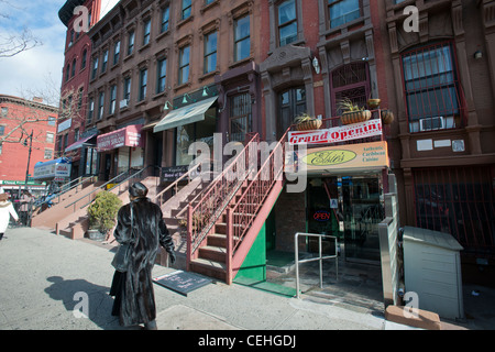 Un gruppo di case di arenaria con retail sul primo e il salotto pavimenti su un blocco in Harlem quartiere di New York Foto Stock