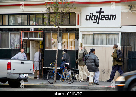 In serata, persone senza fissa dimora di entrambi i sessi immettere CityTeam Ministeri su 6th Street di San Francisco. Foto Stock