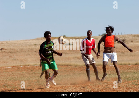 I giocatori di calcio sul polveroso campo rurale, al di fuori di Bloemfontein, stato libero Foto Stock