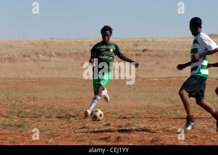 I giocatori di calcio sul polveroso campo rurale, al di fuori di Bloemfontein, stato libero Foto Stock