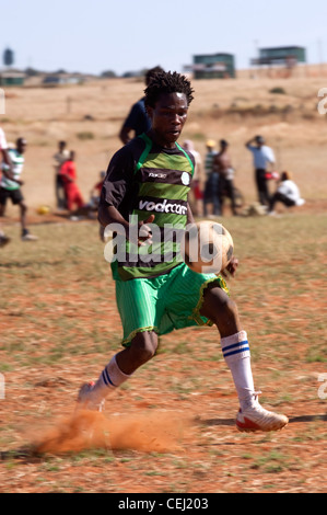 I giocatori di calcio sul polveroso campo rurale, al di fuori di Bloemfontein, stato libero Foto Stock