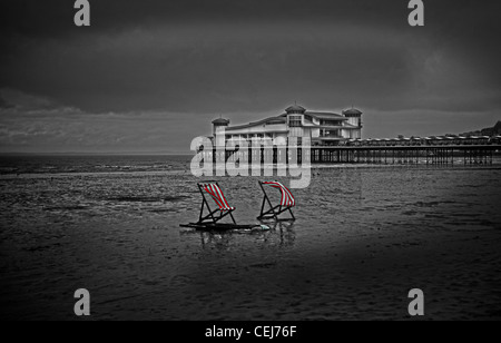 A strisce rosse e bianche sedie a sdraio sul Weston Super Mare spiaggia. Weston Super Mare Pier. British Seaside. Foto Stock