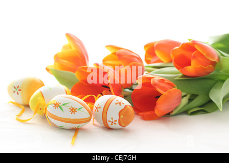 Le uova di pasqua con orange tulipani isolati su sfondo bianco Foto Stock