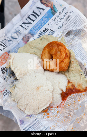 Sud colazione indiana di Idli, ama con un caldo mostarda piccante avvolti in un giornale. Andhra Pradesh, India Foto Stock