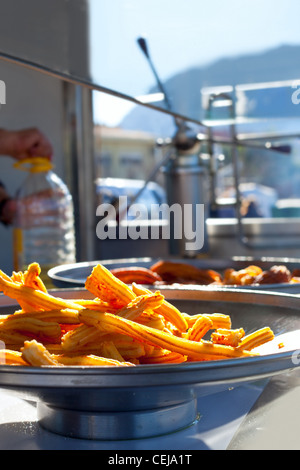 Churros fritti frittelle di farina spagnolo nel mercato Foto Stock