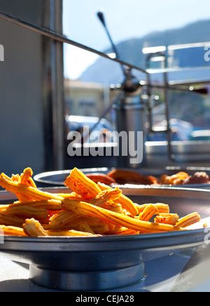 Churros fritti frittelle di farina spagnolo nel mercato Foto Stock