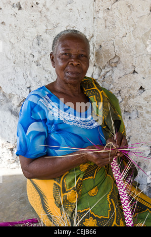 Donna strisce di tessitura utilizzando le fronde delle palme nel villaggio di Bwejuu costa est di Zanzibar Tanzania Foto Stock
