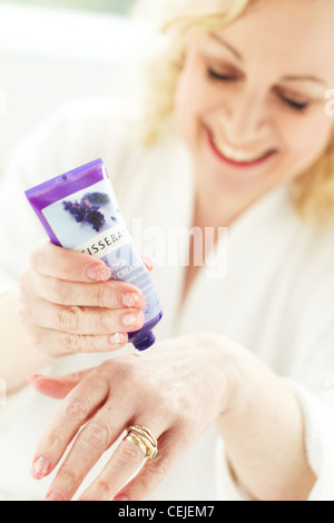 Donna l'applicazione di crema mani Foto Stock