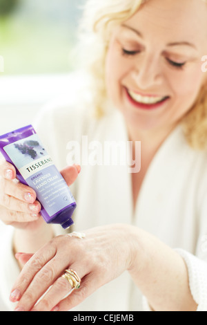 Donna l'applicazione di crema mani Foto Stock