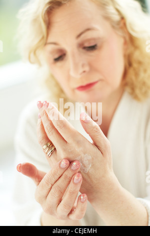 Donna l'applicazione di crema mani Foto Stock