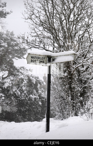 Un alterato in maniera divertente cartello stradale con una copertura di neve nei pressi del villaggio di fondo Waterley vicino a Wotton-under-Edge, Glos UK Foto Stock