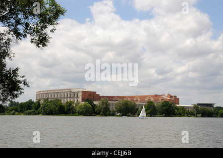 Di fronte ad un grande lago, si trovano gli imponenti resti della Sala dei Congressi (Die Kongresshalle) nell'ex rally nazista di Norimberga, Baviera, Germania. Foto Stock