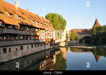 Earl;y mattina sole su una fila di case secolari in legno sulle rive del fiume Pegnitz. Norimberga, Germania Foto Stock