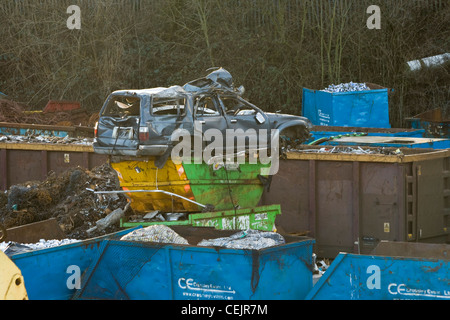 Un auto sulla parte superiore dei cassonetti in un scrapyard. Foto Stock