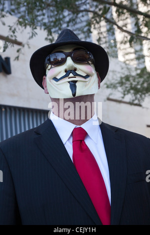 Phoenix, Arizona - un uomo in un abito vestito come un imprenditore, indossa una maschera di Guy Fawkes. Foto Stock