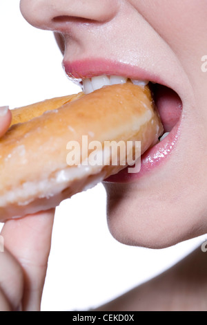 Femmina rosa da indossare lucidalabbra, mangiare ciambella Foto Stock