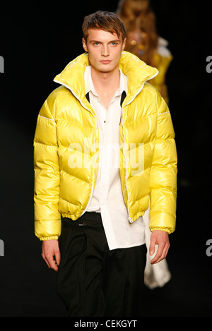 Kris Van Assche Paris Menswear pronto a indossare in autunno e inverno maschio modello indossando giallo brillante zip trapuntato fino giacca puffa grandi Foto Stock