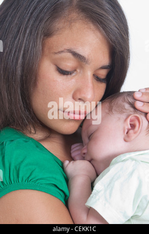 Ritratto di giovane madre mentre tiene il suo neonato Foto Stock