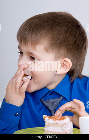 Ritratto di un bambino che mangia la torta Foto Stock