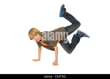 Ragazzo di undici anni che indossa gli auricolari, ascolto di MP3 player e ballando sul pavimento. Foto Stock