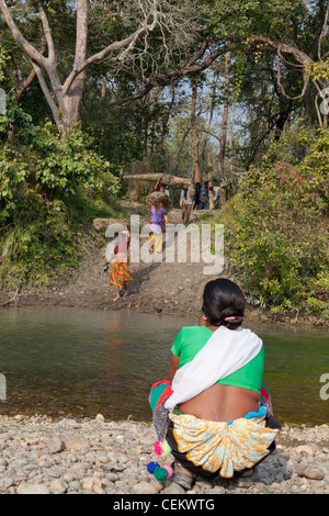 Le persone che attraversano il fiume il taglio di erba stagione Bardia national park in Nepal Asia Foto Stock