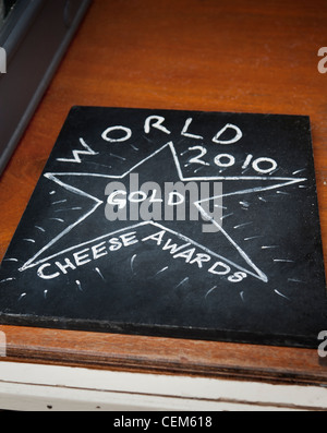 Chalk board su una stalla di mercato del formaggio che legge ' World 2010 GOLD Cheese Awards'. Borough Market Londra Inghilterra Regno Unito Foto Stock