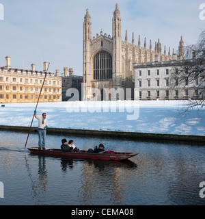 Punting lungo il fiume Cam in inverno la neve con Kings College Chapel per la parte posteriore. Cambridge, Inghilterra. Foto Stock